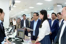 Le Premier ministre Pham Minh Chinh (en chemise bleue) visite le Centre de services administratifs publics de Quang Ninh. Photo: VNA