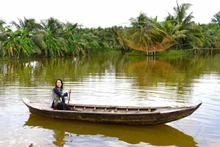 Des visiteurs expérimentent la navigation en pirogue de bois. Photo : vnexpress.net