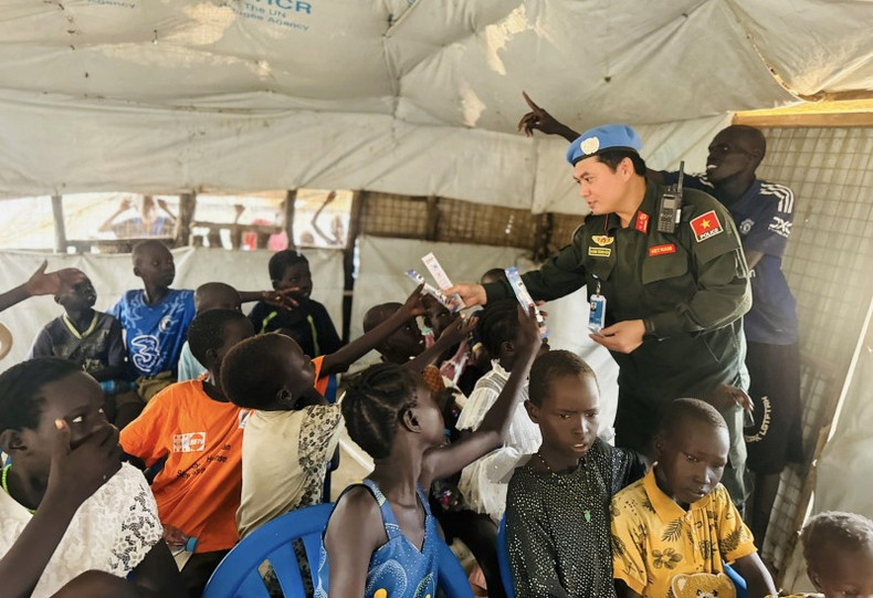 Le lieutenant-colonel Hoang Trong Hoa offre du matériel scolaire à un groupe d’enfants de la classe. Photo : CAND 2.jpg