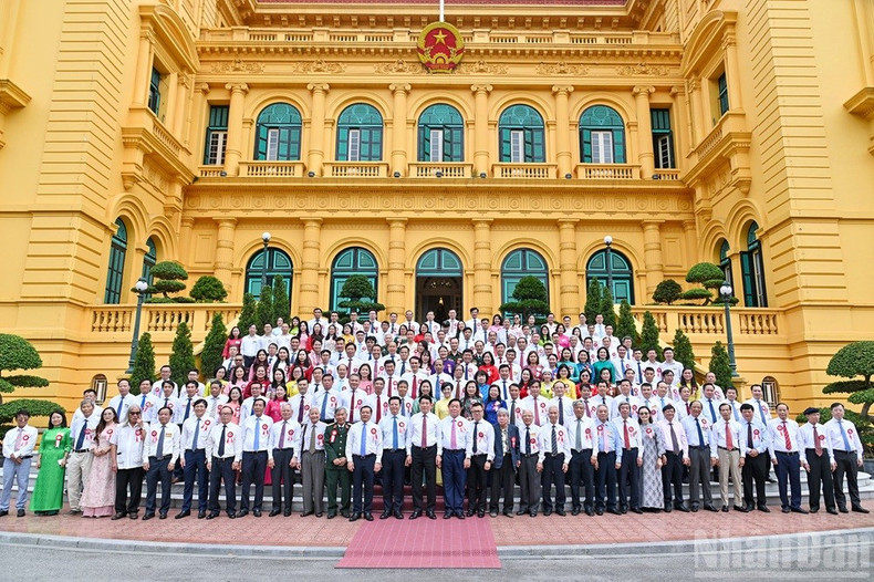 Le président Luong Cuong pose pour une photo souvenir avec les journalistes chevronnés, à Hanoi, le 20 juin. ct1.jpg