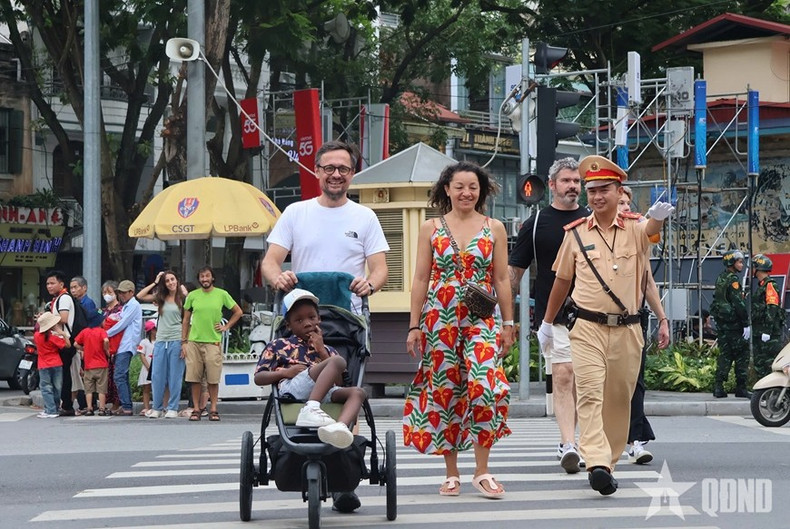 Des touristes étrangers sont orientés vers les emplacements permettant d’assister aux répétitions du défilé. Photo : QDND 1-1222.jpg