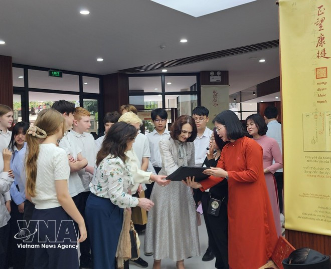 Elena Bezdetko, épouse de l'ambassadeur de Russie au Vietnam, assiste à une présentation sur les planches gravées sur bois de la dynastie des Nguyen. Photo: VNA