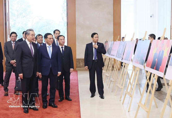 Le vice-Premier ministre vietnamien Bui Thanh Son et le ministre chinois des Affaires étrangères Wang Yi visitent une exposition d'images emblématiques des relations Vietnam-Chine, produite par l'Agence de presse vietnamienne (VNA). Photo : VNA