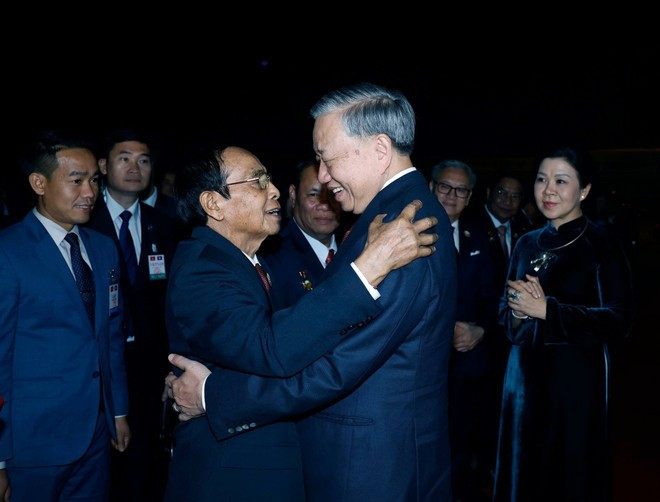 Bounthong Chitmany, membre du Bureau Politique, membre permanent du Secrétariat et vice-président du Laos (à gauche) salue le secrétaire général To Lam et son épouse à l&apos;aéroport international de Wattay, à Vientiane. Photo : VNA