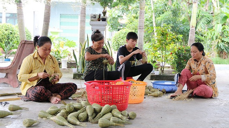 Les habitants khmers du hameau de Giong Dinh, commune de Dai An, fabriquent des objets ménagers miniatures en vannerie, générant ainsi un revenu pour leur foyer. 3.jpg