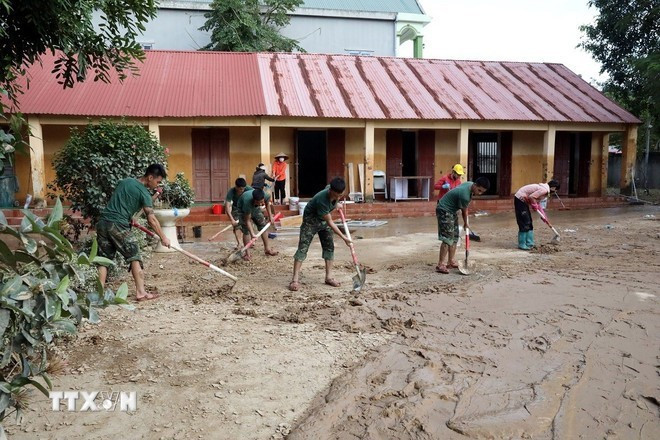 Des officiers et des soldats aident à nettoyer le lycée. Photo : VNA Des officiers et des soldats aident à nettoyer le lycée. Photo : VNA