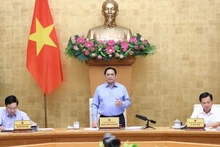 Le Premier ministre Pham Minh Chinh (debout) à la réunion périodique du gouvernement d’août portant sur l'édification de la loi. Photo : VNA.