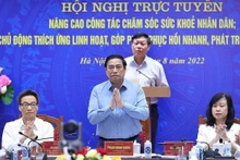 Le Premier ministre Pham Minh Chinh (debout au 1er rang lors de la téléconférence nationale sur le secteur médical, le 21 août. Photo : VNA.