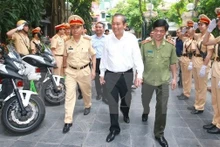 Le vice-PM vietnamien, Truong Hoa Binh (au milieu, chemise blanche), et des resposables du Département de la Police routière. Photo: VNA.