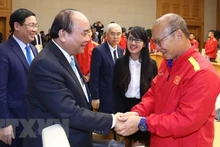 Le Premier ministre Nguyên Xuân Phuc (à gauche) serre la main de l’entraîneur Park Hang-seo, le 21 décembre à Hanoi. Photo : VNA