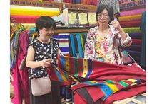 Une visiteuse achète des produits au village de la soie de Van Phuc. Photo : kinhtedothi.vn