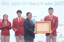 Le Premier ministre vietnamien, Pham Minh Chinh (à gauche), décerne l'Ordre du Travail de deuxième classe au sportif Nguyên Huy Hoàng (natation). Photo : VNA.