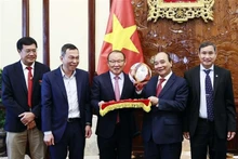 Le Président Nguyên Xuân Phuc avec les entraîneurs Park Hang-seo et Mai Duc Chung, à Hanoi, le 28 mai. Photo : VNA.