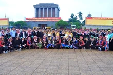 Des artistes ethniques prennent la photo souvenir devant le mausolée du Président Hô Chi Minh. Photo: Village culturel et touristique des ethnies du Vietnam.