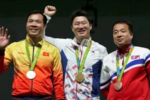 Hoàng Xuân Vinh (1er, à droit) avec sa médaille d’argent. Photo: Reuters.