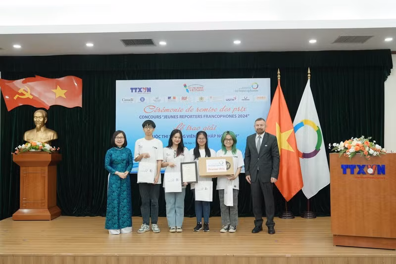 Le groupe d'auteurs reçoit le 1er Prix en 2024, remis par le représentant régional pour l'Asie et le Pacifique de l'OIF, Edgar Doerig, et la directrice générale adjointe de la VNA, Doan Thi Tuyet Nhung.