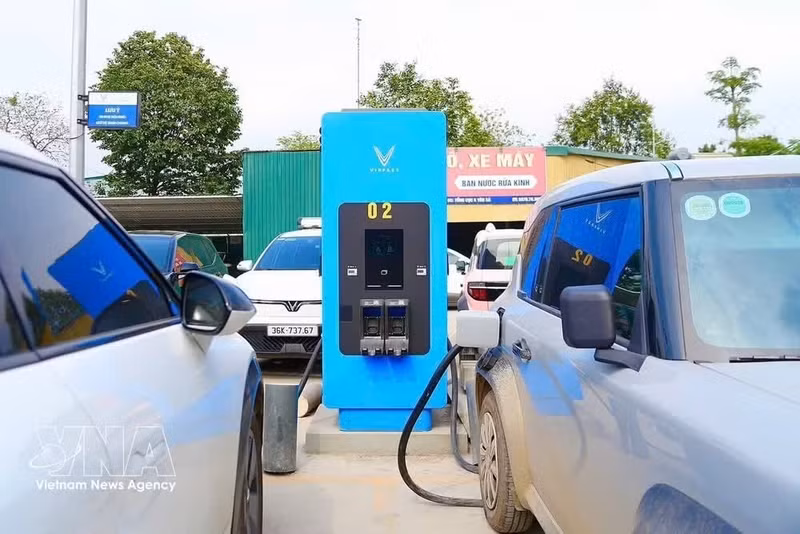 Gros plan sur une borne de recharge VinFast au design moderne, équipée d’un écran d’affichage et d’un câble de recharge standard. Photo : VNA.
