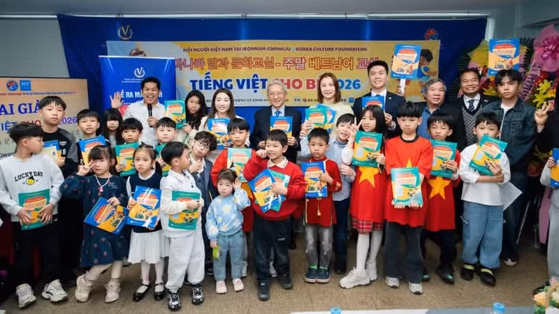 Le comité d’organisation du colloque offre des exemplaires de « Vui hoc tieng Viet » à des enfants vietnamiens vivant actuellement à Gwangju.