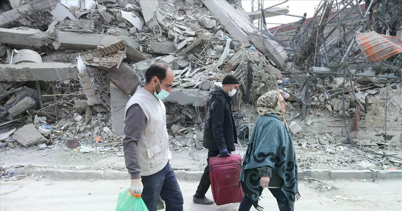 Des personnes marchent à travers les décombres après des attaques. Photo : Xinhua/VNA.