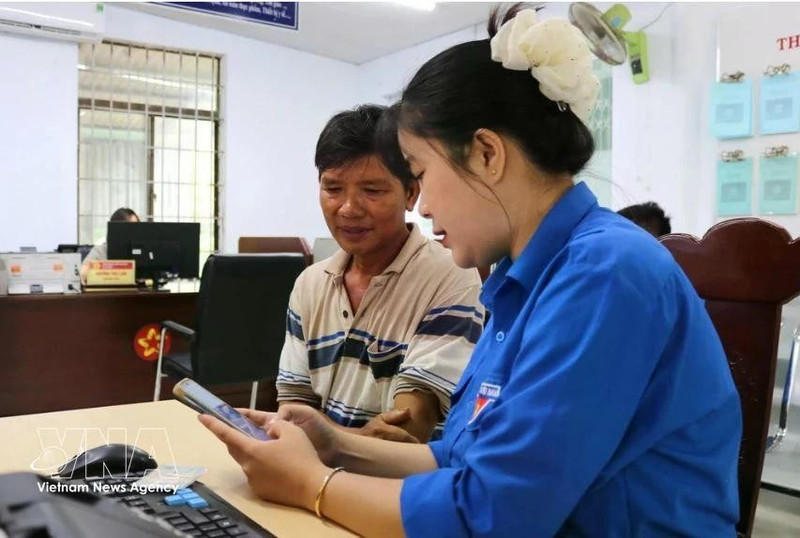 Une membre de l'anntenne de l'Union de la jeunesse communiste Ho Chi Minh à Dak Lak, aide un haibitant local à effectuer une démarche administrative en ligne. Photo : VNA.