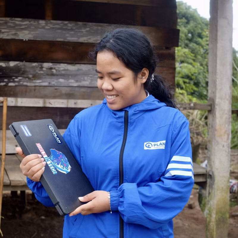 Xuc et l’ordinateur offert par Plan International Vietnam pour soutenir son apprentissage. Photo : Plan International Vietnam.