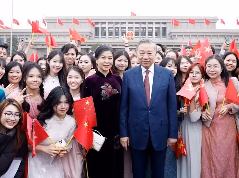 Des représentants de la communauté vietnamienne et des étudiants vietnamiens en Chine accueillent le secrétaire général et président de la République To Lam et son épouse à l’aéroport international de Pékin. Photo : VNA.