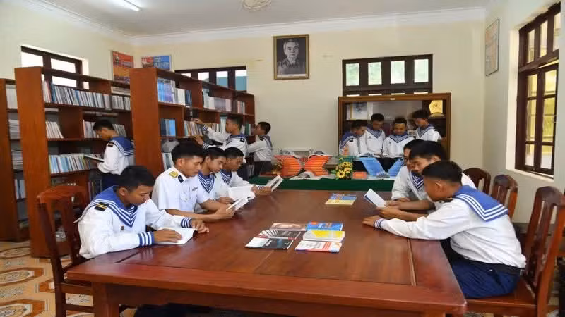 Des soldats de l'île de Son Ca lisent des livres à la bibliothèque. Photo : NDEL.