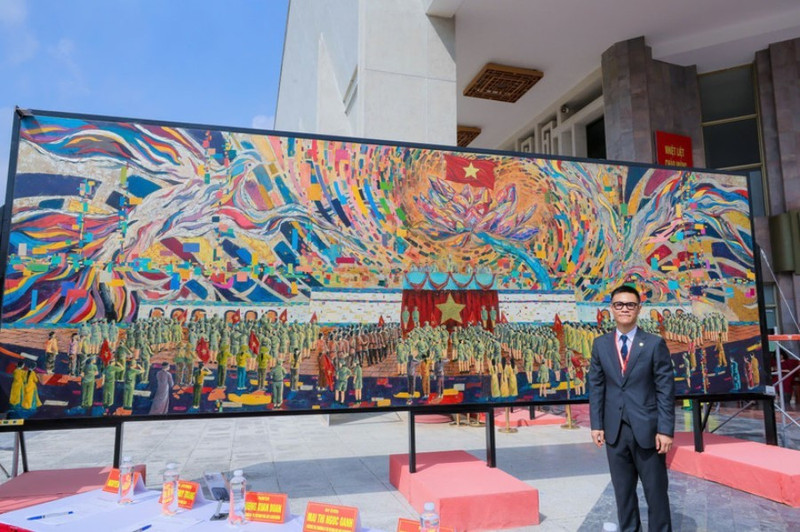Le peintre Chu Nhat Quang à côté de la peinture sur laque grand format, sans assemblage, « l’Oncle Hô lit la Déclaration d'indépendance ». Photo : NDEL.