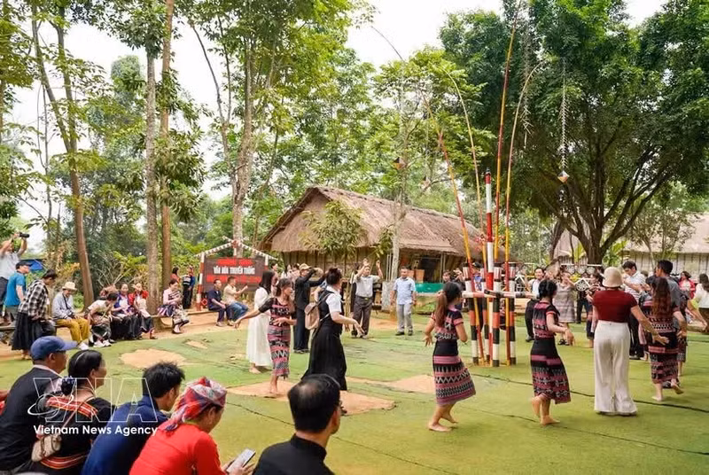 Échanges culturels dans l’espace du village traditionnel de l’ethnie Ba Na au Village culturel et touristique des ethnies du Vietnam, situé dans la commune de Doai Phuong, à Hanoï. Photo : VNA.