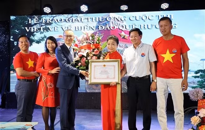 L’ambassadeur du Vietnam en Allemagne, Vu Quang Minh, remet un satisfecit à Bui Thi Thu Minh, cheffe du Comité de liaison des Vietnamiens en Europe « Pour la mer et les îles du Vietnam » et présidente du Club Truong Sa en Allemagne. Photo : VNA.