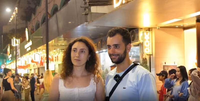 Ce couple espagnol considère le marché nocturne comme une expérience incontournable à Hanoï. Photo : baoquocte.