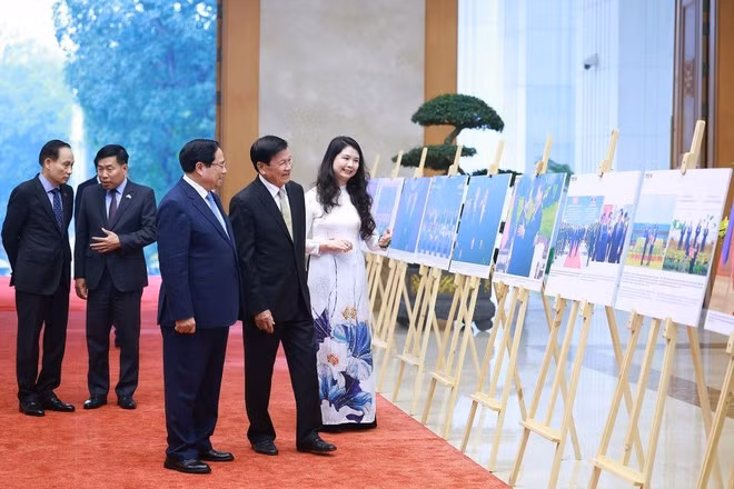 Le Premier ministre Pham Minh Chinh et le secrétaire général du PPRL et président du Laos, Thongloun Sisoulith, visitent une exposition de photos sur la coopération bilatérale, organisée par l'Agence vietnamienne d'Information (VNA). Photo : VNA.