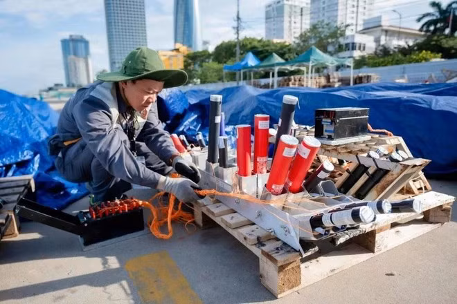 Les membres de l'équipe vietnamienne mettent la dernière main aux préparatifs du feu d'artifice de la dernière nuit, le 12 juillet. Photo : VTC.