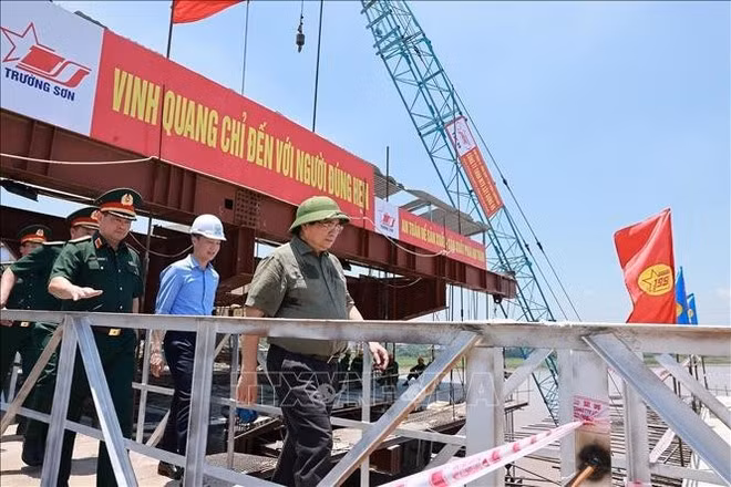 Le Premier ministre Pham Minh Chinh inspecte l'avancement des travaux de construction du nouveau pont de Phong Chau. Photo : VNA.