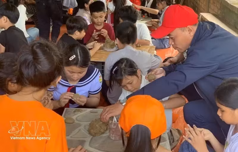 Des élèves de l'école primaire Phu My 1 découvrent la fabrication de poterie au village de potiers de Phuoc Tich, à Hue. Photo : VNA.