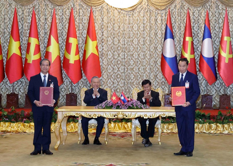 Le secrétaire général To Lam et le secrétaire général du PPRL et président lao, Thongloun Sisoulith, supervisent l’échange des accords de coopération entre les deux pays. Photo : VNA.