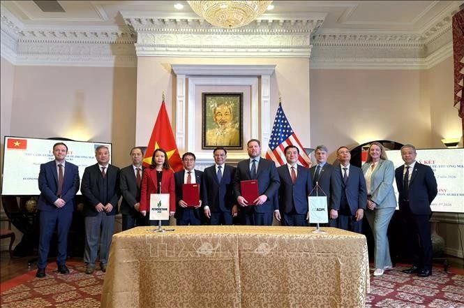La cérémonie de signature d'un protocole d'accord entre des représentants vietnamiens et américains. Photo : VNA.