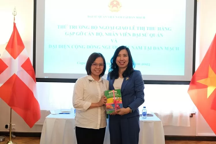 La vice-ministre Le Thi Thu Hang présente des livres de vietnamien à une représentante de la communauté au Danemark. Photo : baoquocte. thu-truong-bo-ngoai-giao-le-thi-thu-hang-gap-go-tri-an-cac-the-he-kieu-bao-tai-dan-mach-va-thuy-dien-20250711071332.png