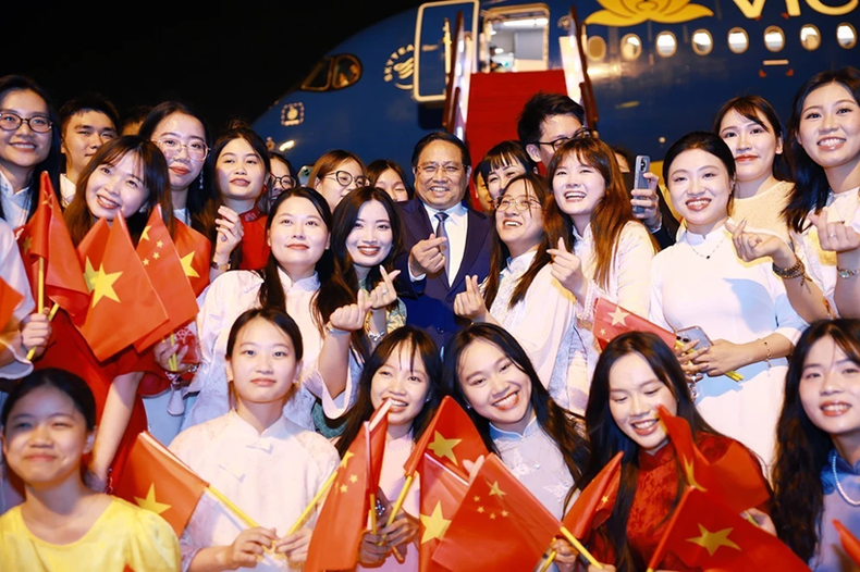 Le Premier ministre Pham Minh Chinh et des étudiants vietnamiens à l’aéroport. Photo : VNA. vnapotalthutuongphamminhchinhketthucchuyenlamviectaitrungquoc8116267-1750945867684536757853.png
