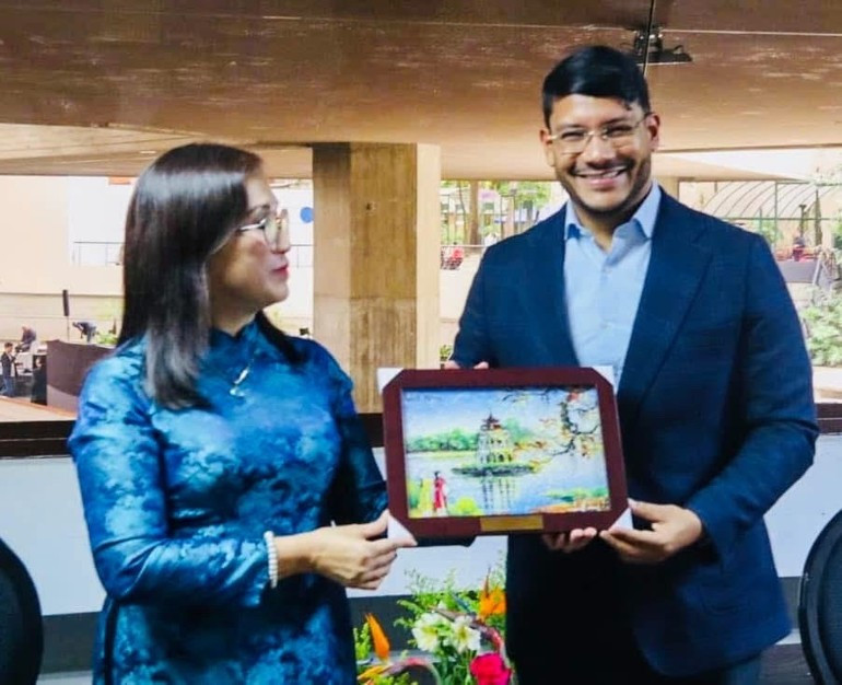 Mme Dinh Thi Mai remet un cadeau à Rander Peña, vice-président chargé des relations extérieures du Parti socialiste unifié du Venezuela. Photo : Ambassade du Vietnam au Venezuela. tg1.jpg