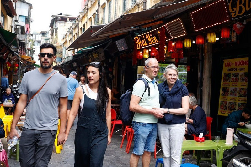 Touristes étrangers visitant le vieux quartier de Hanoi avec ses marchés, la street food, les spectacles traditionnels et ses sites historiques. Photo : VNA.