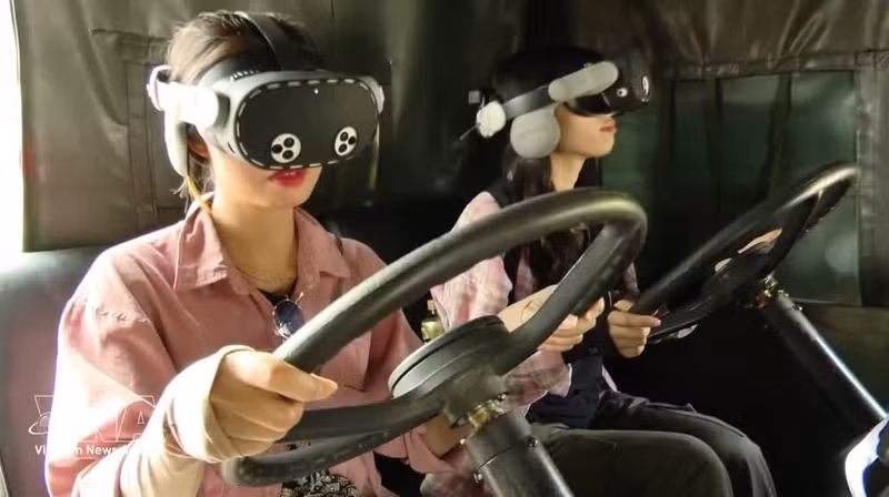 Des touristes découvrent la conduite sur la piste de Truong Son grâce à la technologie de réalité virtuelle 9D (VR360). Photo : VNA