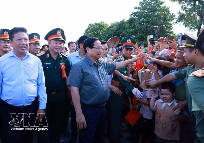 Le Premier ministre Pham Minh Chinh aux côtés de la population dans la zone du projet du nouveau pont Phong Chau, sur la Route nationale 32C. Photo : VNA.