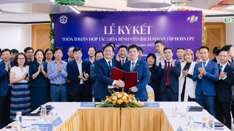 Đao Xuan Co, directeur de l'Hôpital Bach Mai et Nguyên Van Khoa, directeur général du Groupe FPT, échangeant l'accord de coopération.