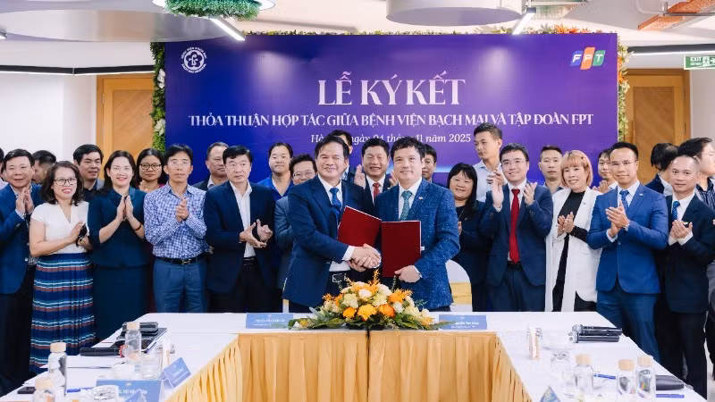 Đao Xuan Co, directeur de l'Hôpital Bach Mai et Nguyên Van Khoa, directeur général du Groupe FPT, échangeant l'accord de coopération.