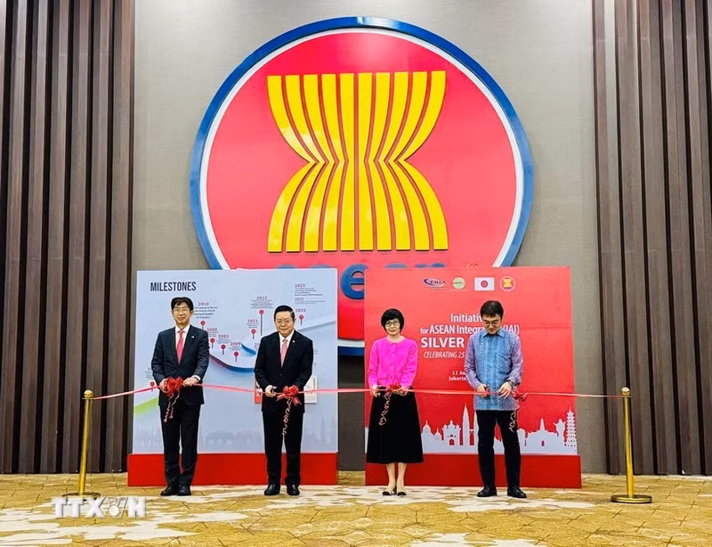 Les délégués coupent la bande inaugurale de l’exposition de photos célébrant le 25e anniversaire de l’IAI. Photo : VNA.