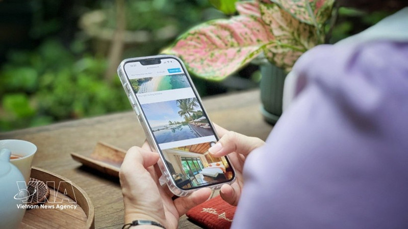 Avec un simple smartphone en main, les touristes peuvent rechercher et réserver divers services pour leur voyage. Photo : VNA.