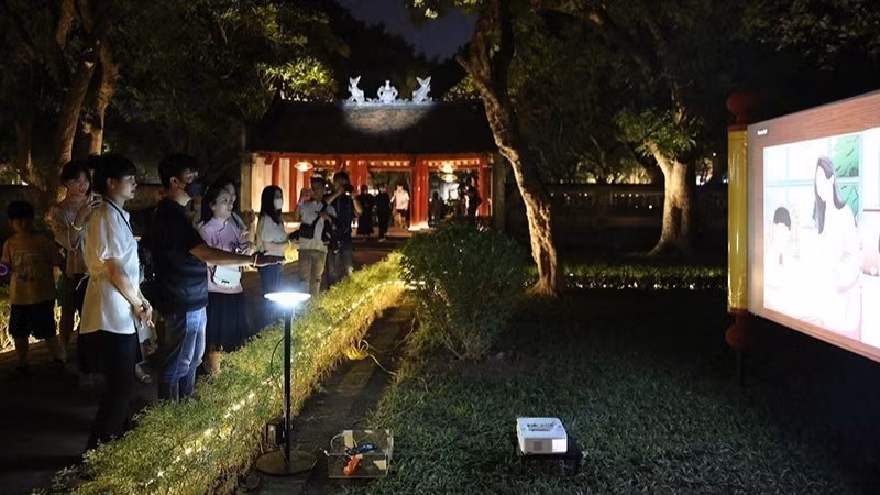 Des touristes participent à l'excursion « Découvrez la nuit à Van Mieu-Quoc Tu Giam ». (Photo : nhandan.vn)