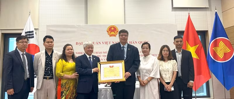 Le président du Comité central du Front de la Patrie du Vietnam, Do Van Chien, a remis un certificat de mérite au collectif de l’Association des Entrepreneurs et Investisseurs Vietnam-République de Corée. Photo : VKBIA. 