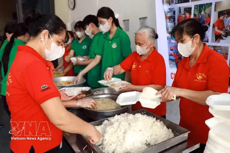 Des membres de l'Association des bénévoles pour les repas (quartier de Thien Truong) et des élèves du lycée Nguyen Khuyen (quartier de Nam Dinh) préparent des repas gratuits destinés aux patients. Photo : VNA.